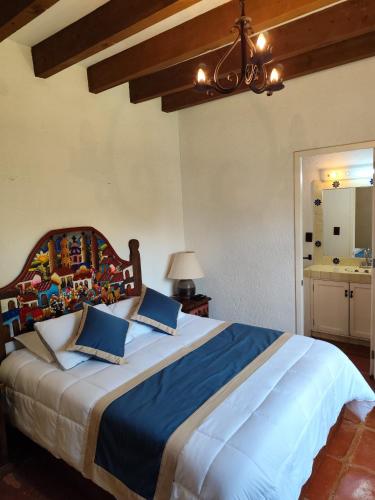 a bedroom with a large bed with blue pillows at Casa de las Conchas Cuernavaca in Cuernavaca