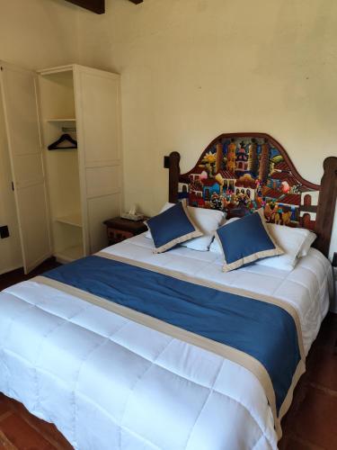a bedroom with a large bed with a wooden headboard at Casa de las Conchas Cuernavaca in Cuernavaca