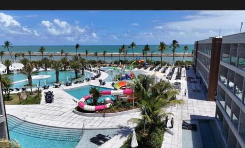 a view of a resort with a pool and the ocean at Gave risort Porto life 2 in Porto De Galinhas
