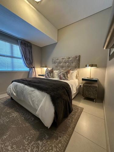 a bedroom with a large bed and a window at Meerendahl Luxury Apartments at Heritage Square in Durbanville