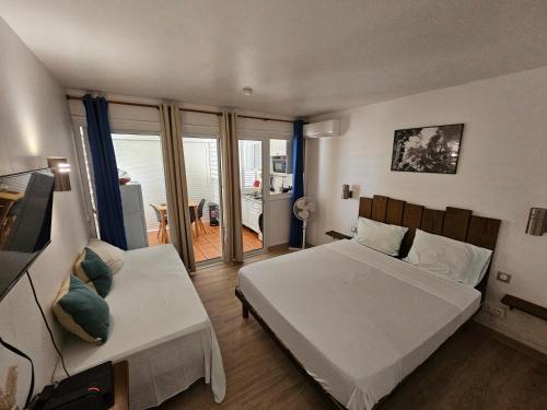 a bedroom with two beds and a balcony at COZY Studio 331 ADR in Saint-François