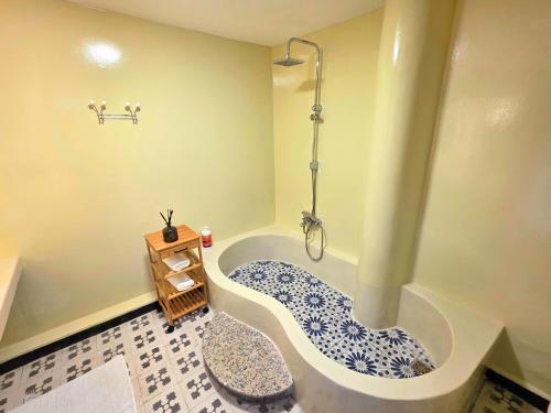 a bathroom with a bath tub with a shower at Riad Boutique Baba in Rabat