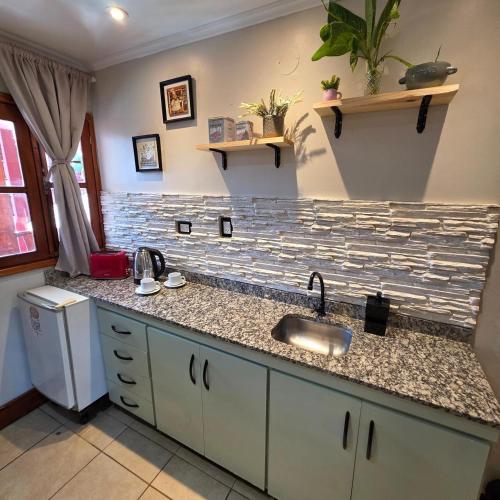 a kitchen with a sink and a counter top at Tupa Hotel Iguazu in Puerto Iguazú