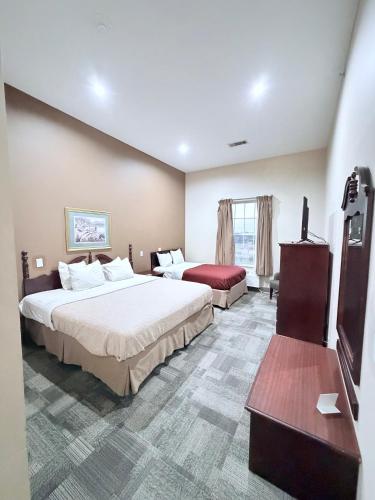 a hotel room with two beds and a television at COLLINS INN & SUITES in Collins