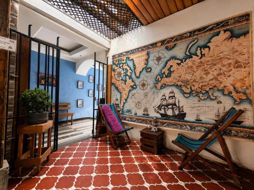 a mural on the wall of a room with a map at Amura Hostel - Antigua Guatemala in Antigua Guatemala