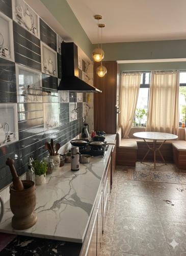 a kitchen with a counter top and a living room at Karma homestay in Ravangla