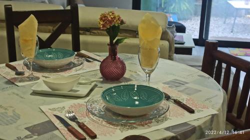 a table with two plates and a vase with flowers at Villa Anita Spa in Piriápolis