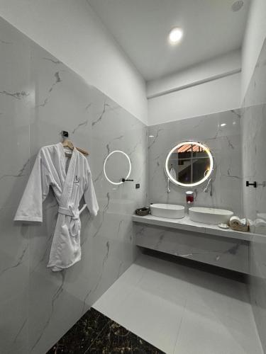 a bathroom with a robe hanging on a wall at Mansión Altamirano - Hotel in Talavera