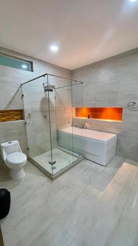 a bathroom with a glass shower and a toilet at Casa lujosa lorica in Lorica