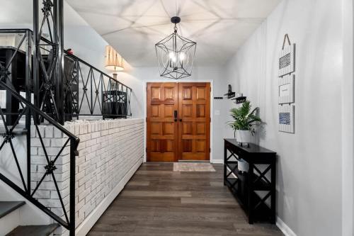 a hallway with a staircase and a wooden door at Arden Place - Spacious Retreat with Pool in High Point