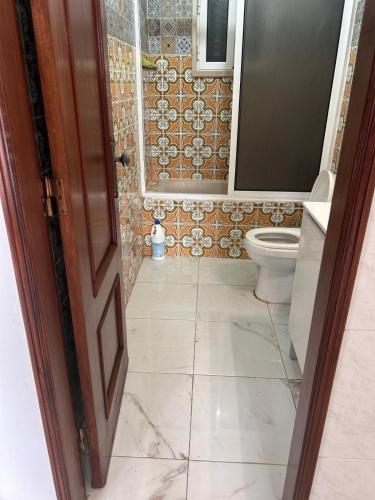 a bathroom with a toilet and a tiled floor at ABRA residence alverca in Quinta da Verdelha