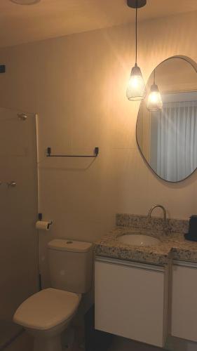 a bathroom with a toilet and a sink and a mirror at Vila confort in Vila Velha
