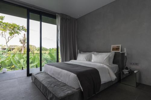 a bedroom with a large bed and a large window at UNIT Nuanu Village in Canggu