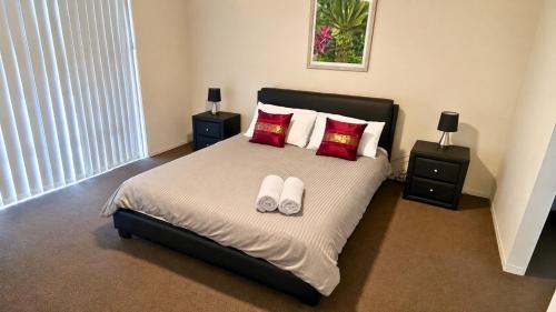 a bedroom with a bed with two pillows and two night stands at Napolean Holiday Retreat in Vasse
