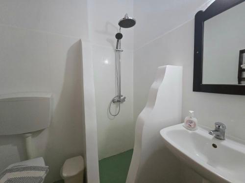 a white bathroom with a sink and a mirror at Agla Studio 2 in Fournoi