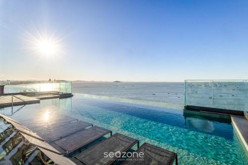 a swimming pool with a view of the ocean at Studios in a seaside building, close to Beto Carreiro at Penha Spot - PSOB in Gravata