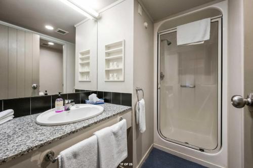 a bathroom with a sink and a shower at Parklane Motor Lodge in Auckland
