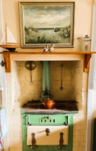 a green stove with a picture on top of it at Lazy Shanty in American River