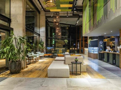 a lobby with couches and tables in a building at ibis Styles Porto Alegre Moinhos de Vento in Porto Alegre