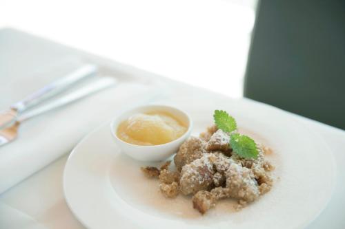 a plate of food with a bowl of dipping sauce at Hotel am See in Hard