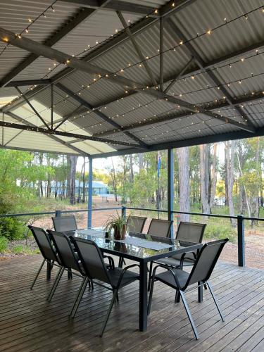 a patio with a glass table and chairs on a deck at Diamond Lake Escape in Collie