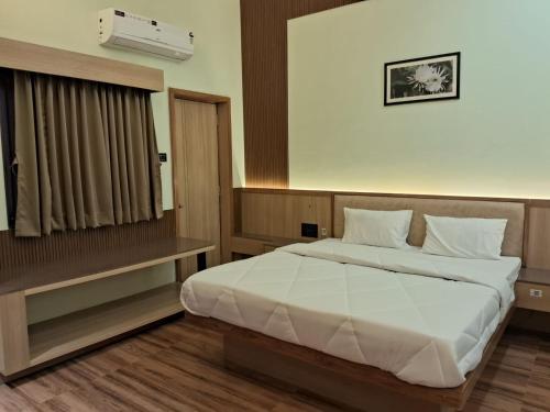 a bedroom with a large bed and a window at Hotel Brindavan Grand in Gulbarga