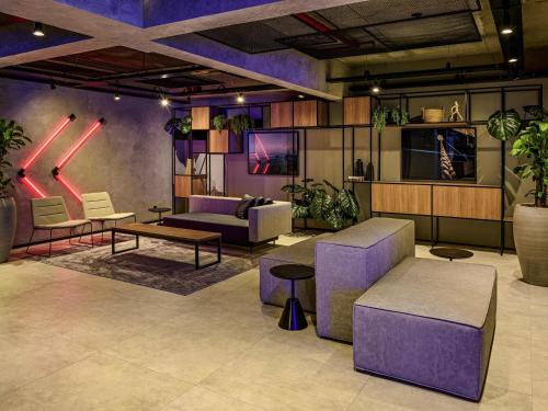 a living room with purple furniture and potted plants at Ibis Budget Balneario Camboriu in Balneário Camboriú