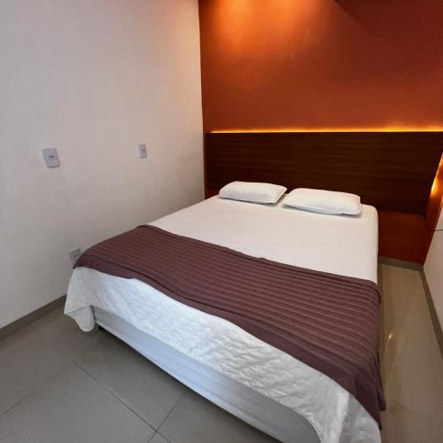 a bedroom with a bed with two pillows on it at Apartamento 2 Quartos centro da cidade in Parauapebas
