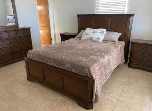 a bedroom with a large bed and two dressers at Cozy House, Ocean View, Saint Thomas in Contant