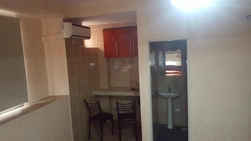 a small kitchen with two chairs and a sink at Hotel El Porteño in Buenos Aires