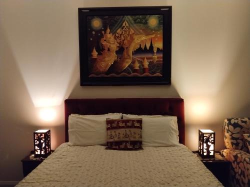 a bedroom with a bed with a picture on the wall at Tree of Love in Cambridge