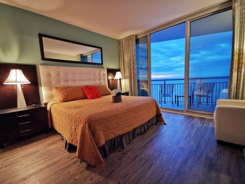 a bedroom with a bed with a view of the ocean at Oceanfront Paradise Sleeps 10 w Stunning Sunrises in Myrtle Beach