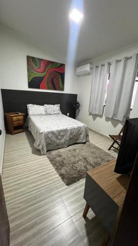 a bedroom with a bed and a rug at Recanto Guarujá Moc in Montes Claros