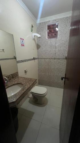 a bathroom with a toilet and a sink and a shower at Recanto Guarujá Moc in Montes Claros