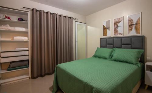a bedroom with a green bed and a closet at Refúgio do poeta in Natal