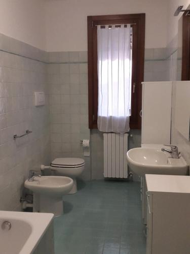 ネグラールにあるAppartamento Valparadisoのバスルーム(トイレ2つ、洗面台、窓付)