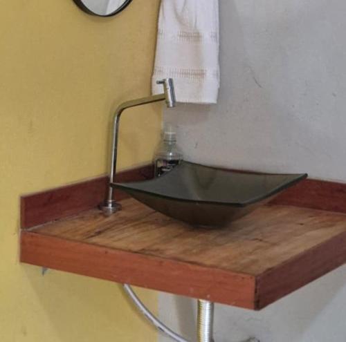 a sink on a wooden table with a soap bottle at Chalés Mirante da Lua Chalé 4 in Cavalcante
