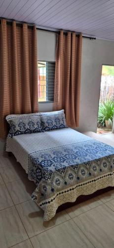 a bedroom with a bed with blue sheets and curtains at Chalés Mirante da Lua Chalé 4 in Cavalcante