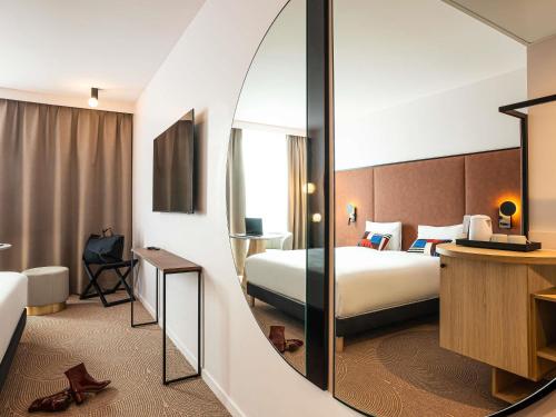a hotel room with a bed and a mirror at Mercure Dunkerque Centre Gare in Dunkerque