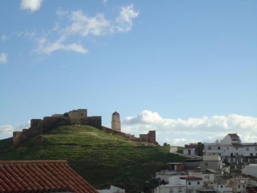 a castle on top of a hill with buildings at Apartamentos Candela Alora in Alora