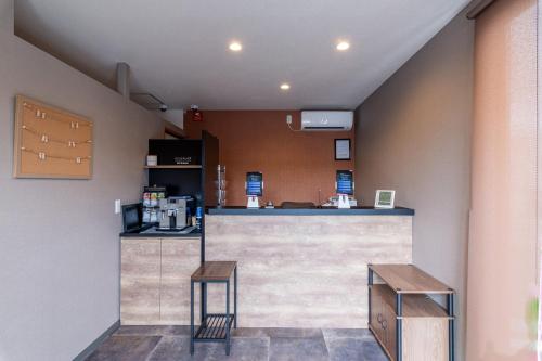 a bar in a restaurant with two stools at HOTEL R9 The Yard Yamaga in Kumamoto