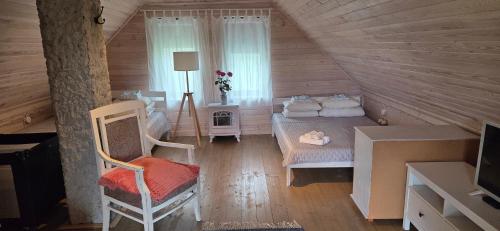 a attic room with two beds and a window at Üleoja Saunaholiday in Kaagvere