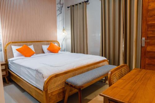 a bedroom with a bed with orange pillows and a table at Ricefield View 2 BR villa near Canggu in Dalung