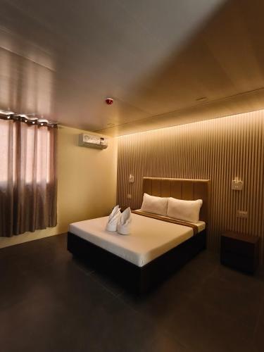 a bedroom with a bed with two towels on it at Claytown Pension House in Dumaguete