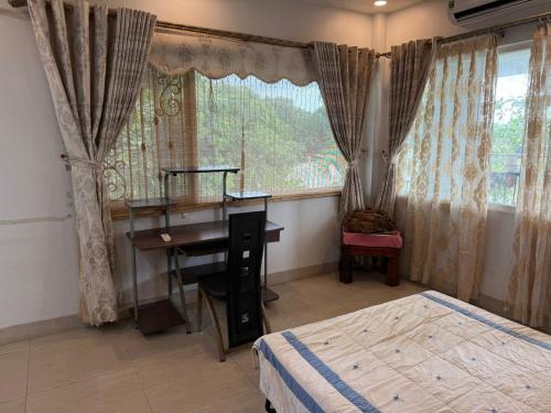 a bedroom with a desk and a bed and a window at Cactos Pool & Palms Local Stay in Ho Chi Minh City