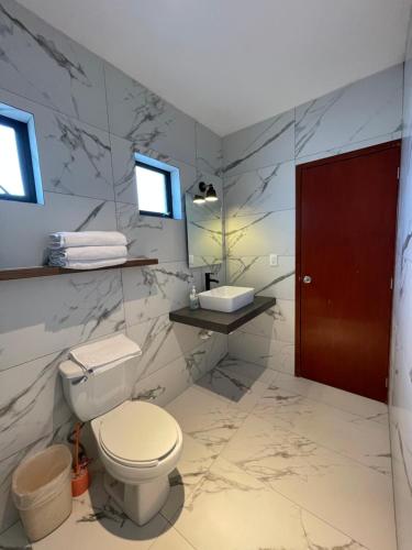 a bathroom with a toilet and a sink at Casa Fénix in Tepic