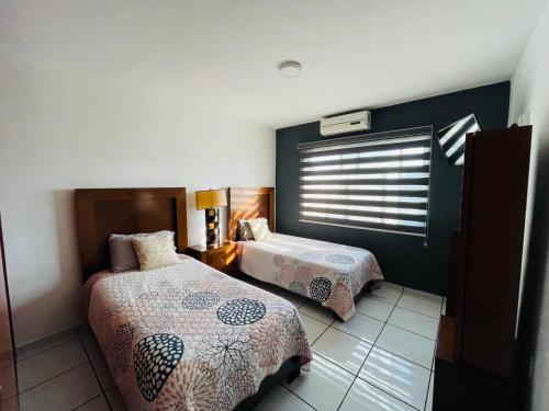 a bedroom with two beds and a window at Casa Fénix in Tepic