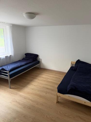 a bedroom with two beds and a wooden floor at Monteurhome Monteurzimmer A7 A5 in Niederaula