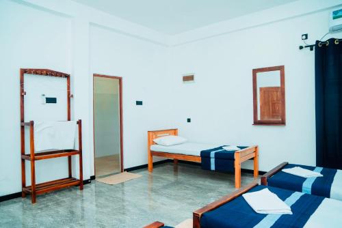a room with two beds and a mirror at Grace Inn in Kalkudah