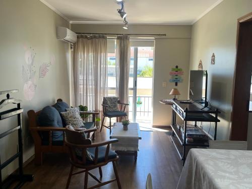 a living room with a couch and a tv at Conforto e simplicidade no centro da cidade in Santana do Livramento